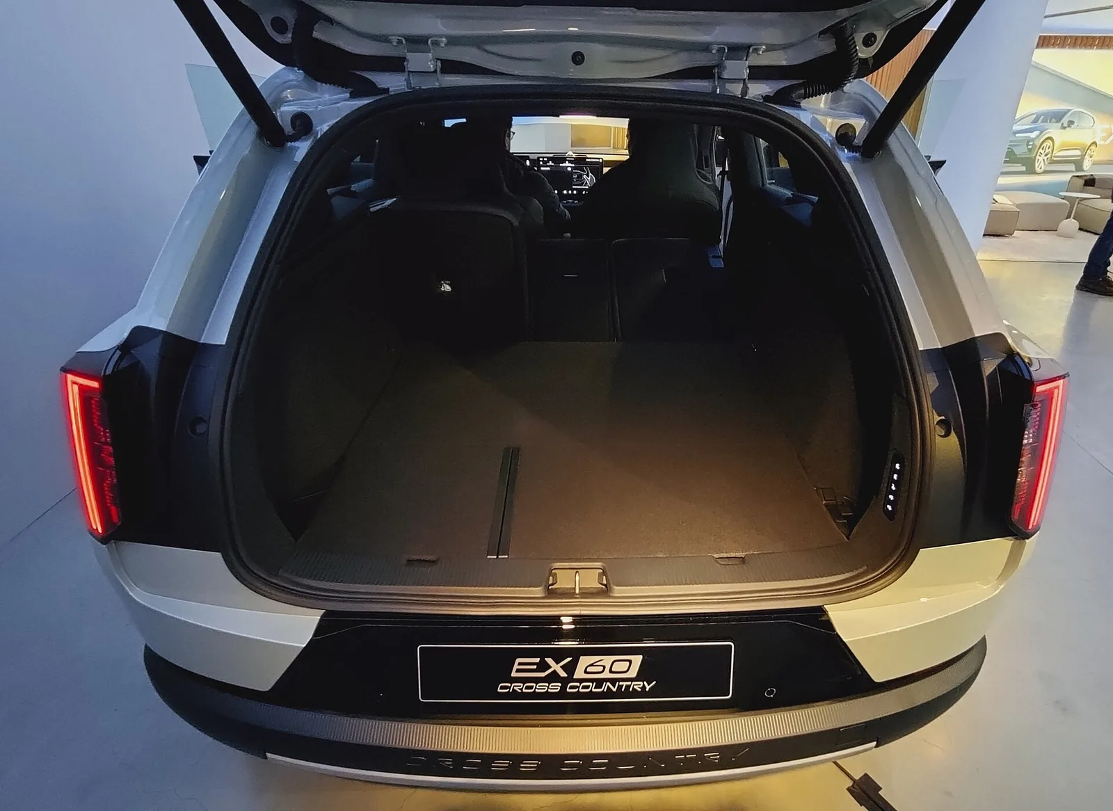Coffre ouvert d'un Volvo EX60 Cross Country vu de l'arrière, avec banquette en place